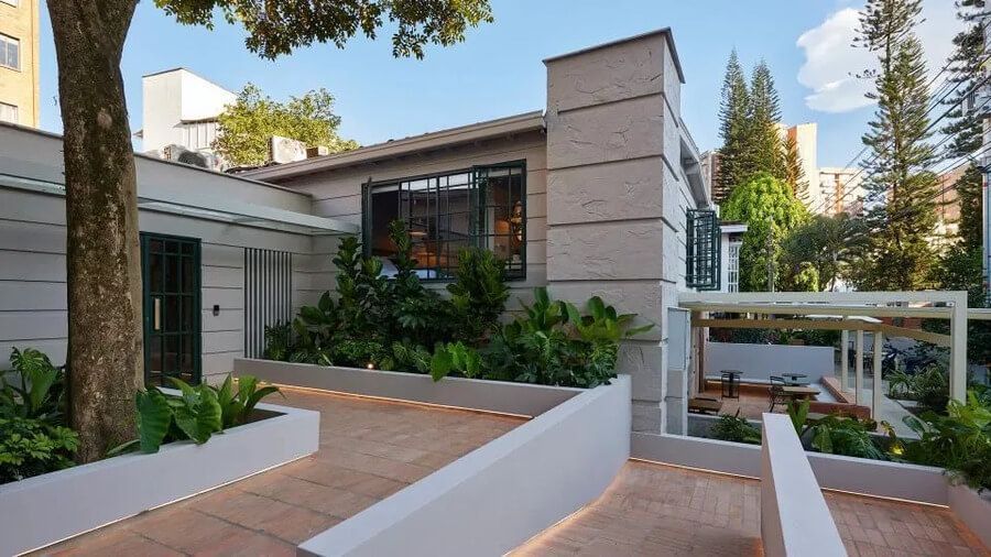 Exterior moderno de un hotel rodeado de vegetación y terrazas al aire libre