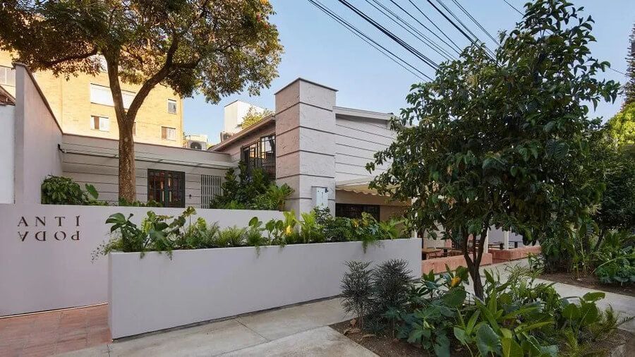 Fachada moderna del hotel con jardines y árboles en un entorno urbano