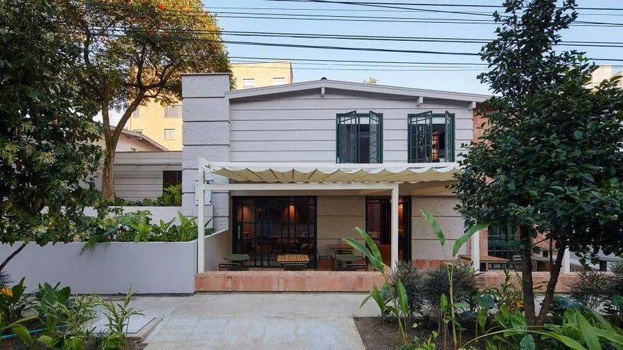 Fachada principal del hotel con terraza y jardín en un ambiente tranquilo y acogedor