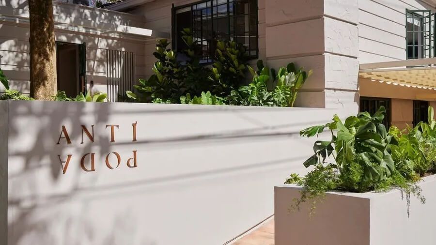 Entrada del hotel Antípoda con diseño moderno y jardineras decorativas