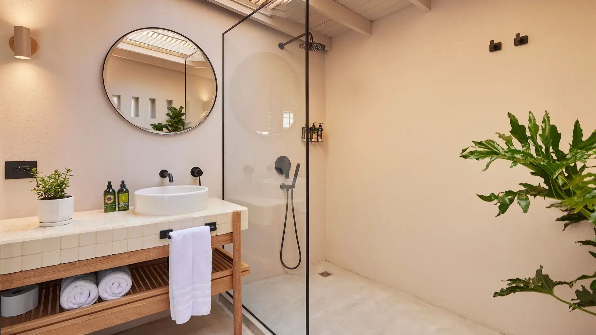 Baño moderno con ducha de las habitaciones de suite superior Lombok en el Antípoda Hotel Boutique Medellín.