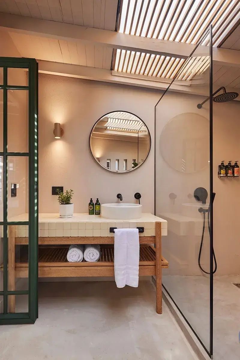 Espejo en el baño de las habitaciones de suite superior Lombok en el Antípoda Hotel Boutique Medellín, con diseño elegante y moderno, lavabo y ducha de vidrio.