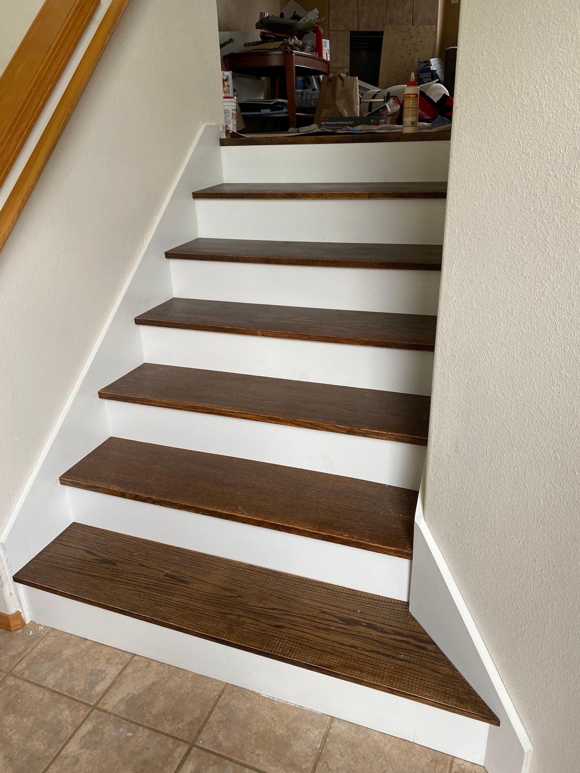 Wooden stair treads painted white, ascending with a brown wood grain.