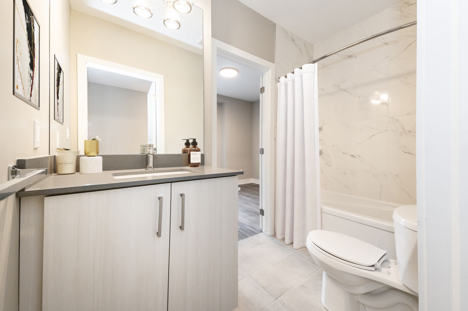 A bathroom with a sink , toilet , bathtub and mirror.