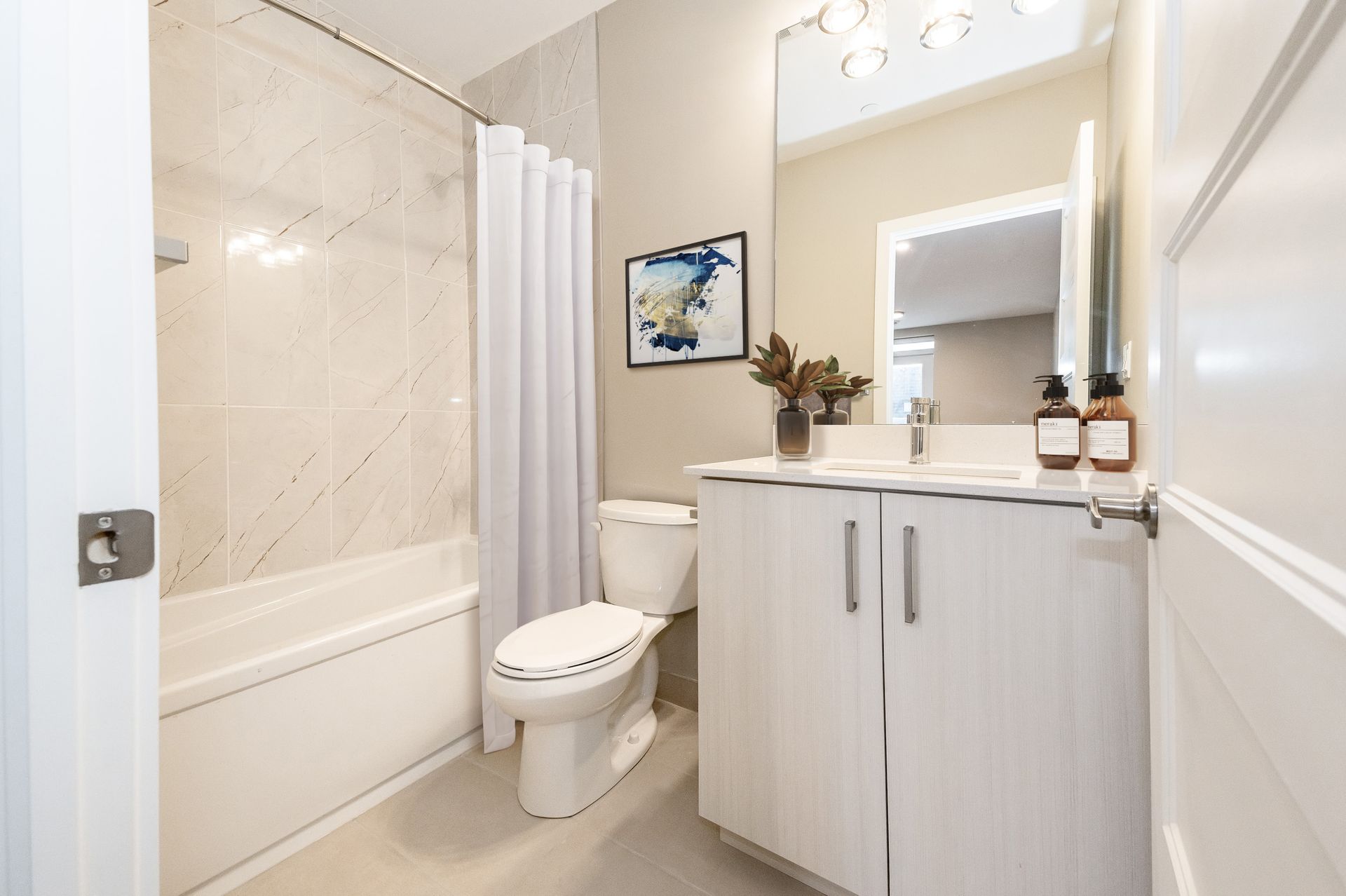 A bathroom with a toilet , sink , bathtub and mirror.