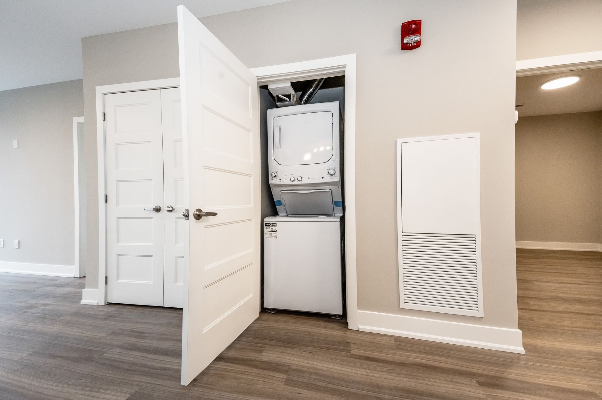 A washer and dryer are stacked on top of each other in a closet.