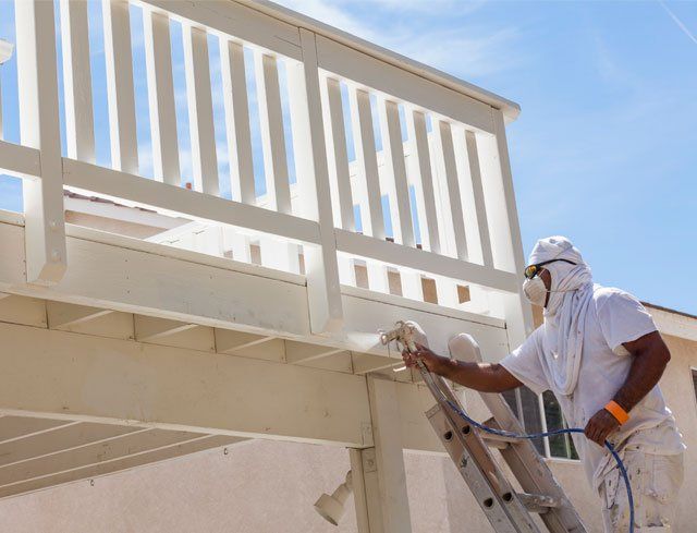 Exterior Painting — Painter Spraying the Deck in Jacksonville, FL