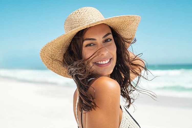 women with tan hat at the beach