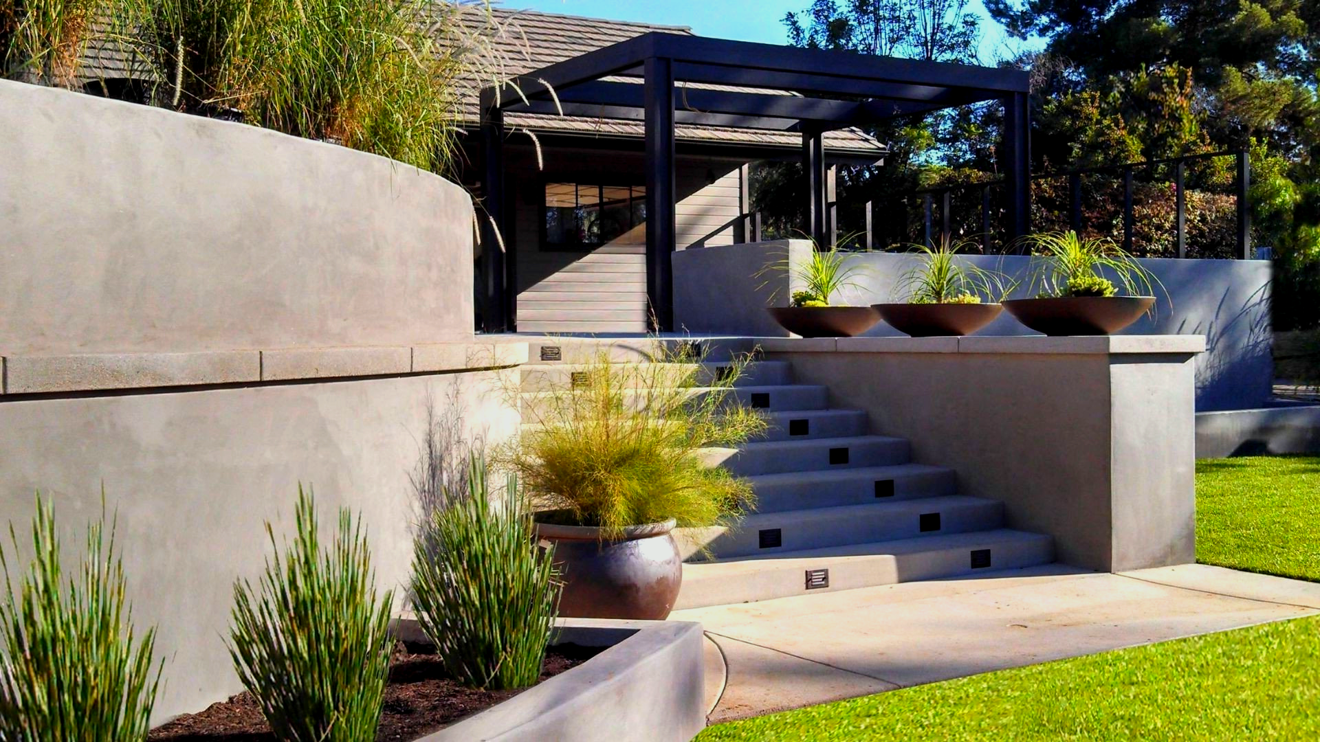 A staircase leading up to a house with potted plants in front of it.