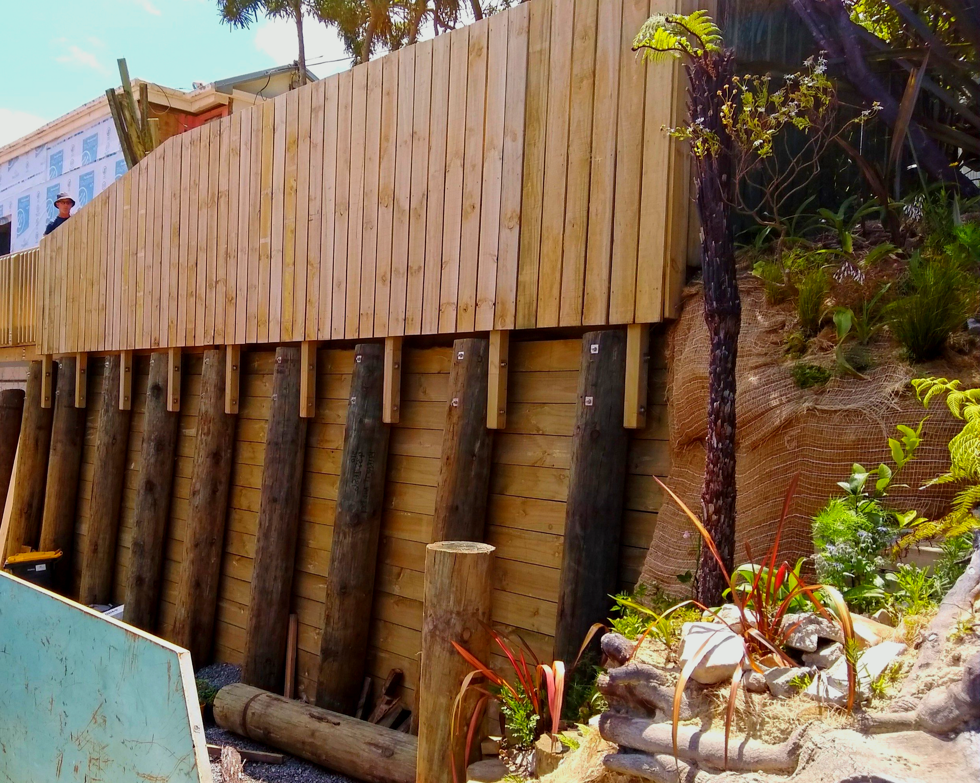 A wooden fence is being built on a hillside