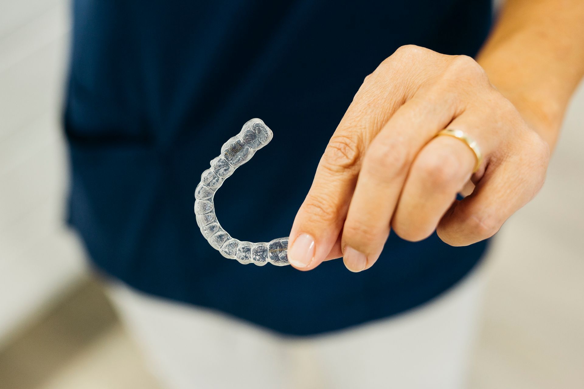 A person is holding a clear brace in their hand.