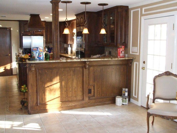 A kitchen with a large wooden counter and a chair