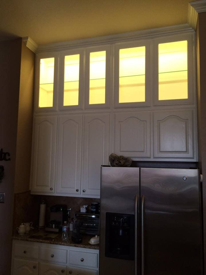 A kitchen with white cabinets and a stainless steel refrigerator
