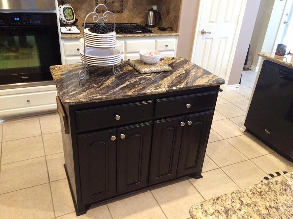 A kitchen with black cabinets and granite counter tops