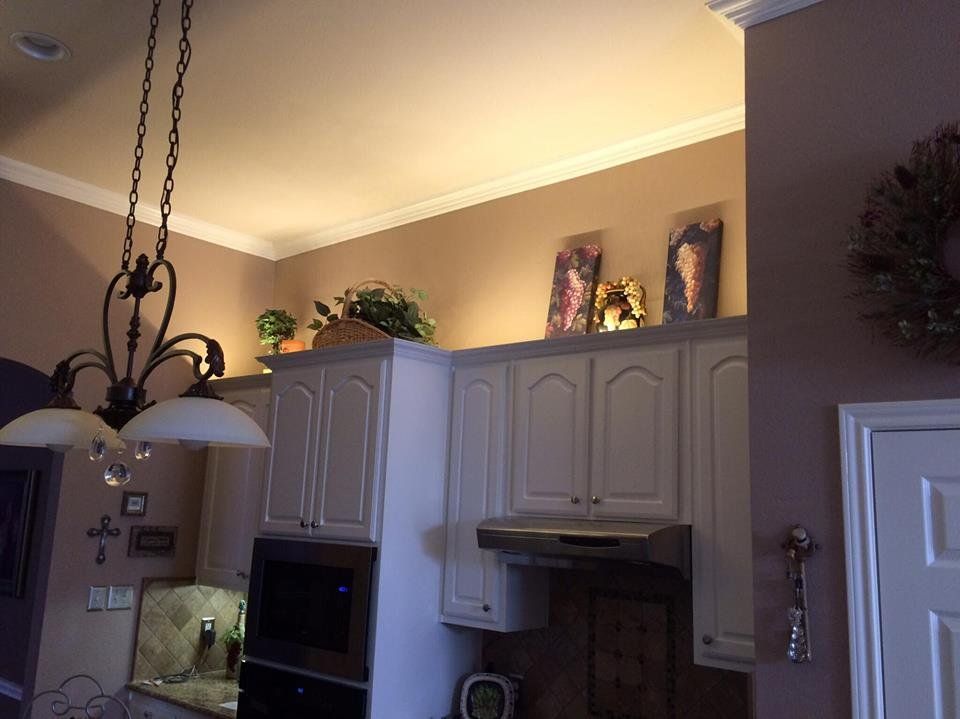 A kitchen with white cabinets and a chandelier hanging from the ceiling