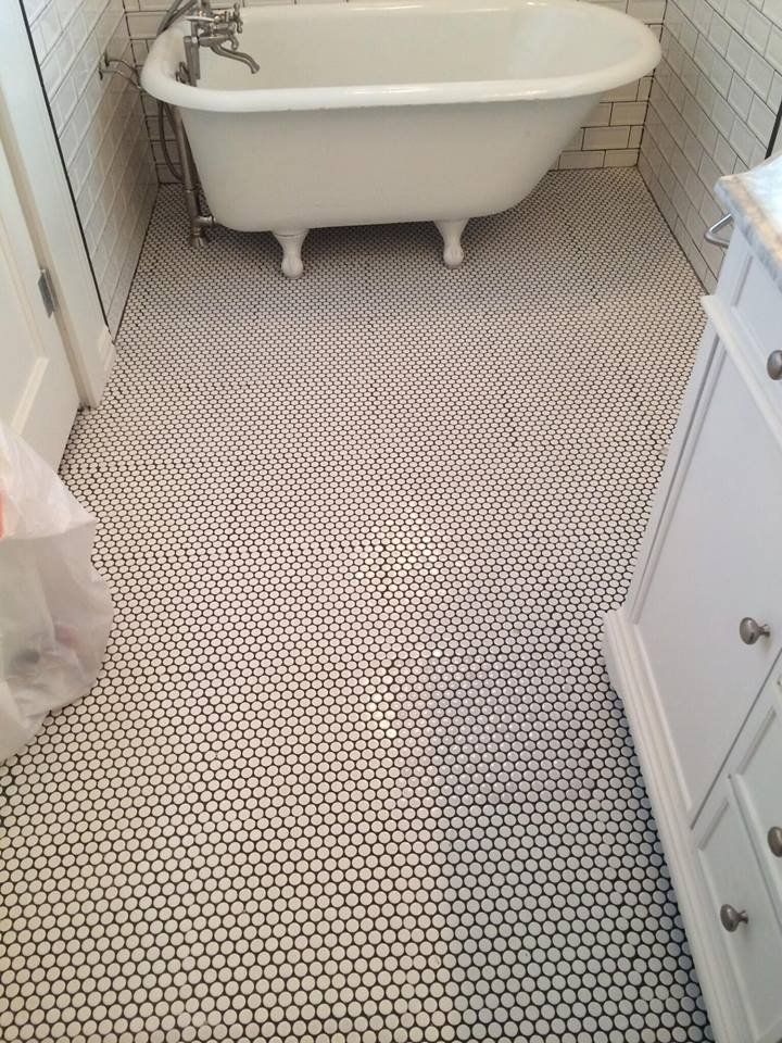 A bathtub is sitting on a tiled floor in a bathroom