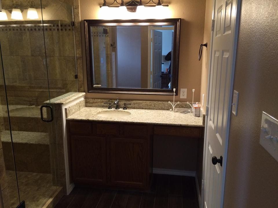 A bathroom with a sink , mirror and walk in shower