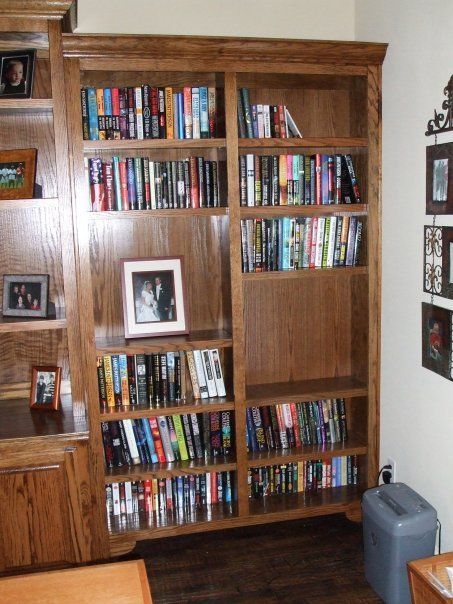 A bookshelf filled with lots of books and pictures