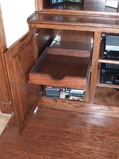 A wooden cabinet with a drawer pulled out of it
