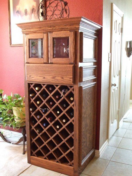 A wooden wine rack in a room with a red wall