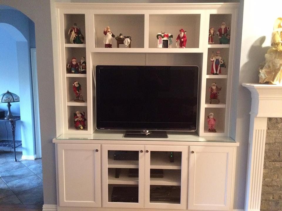 A white entertainment center with a flat screen tv