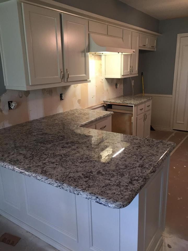 A kitchen with granite counter tops and white cabinets is being remodeled.