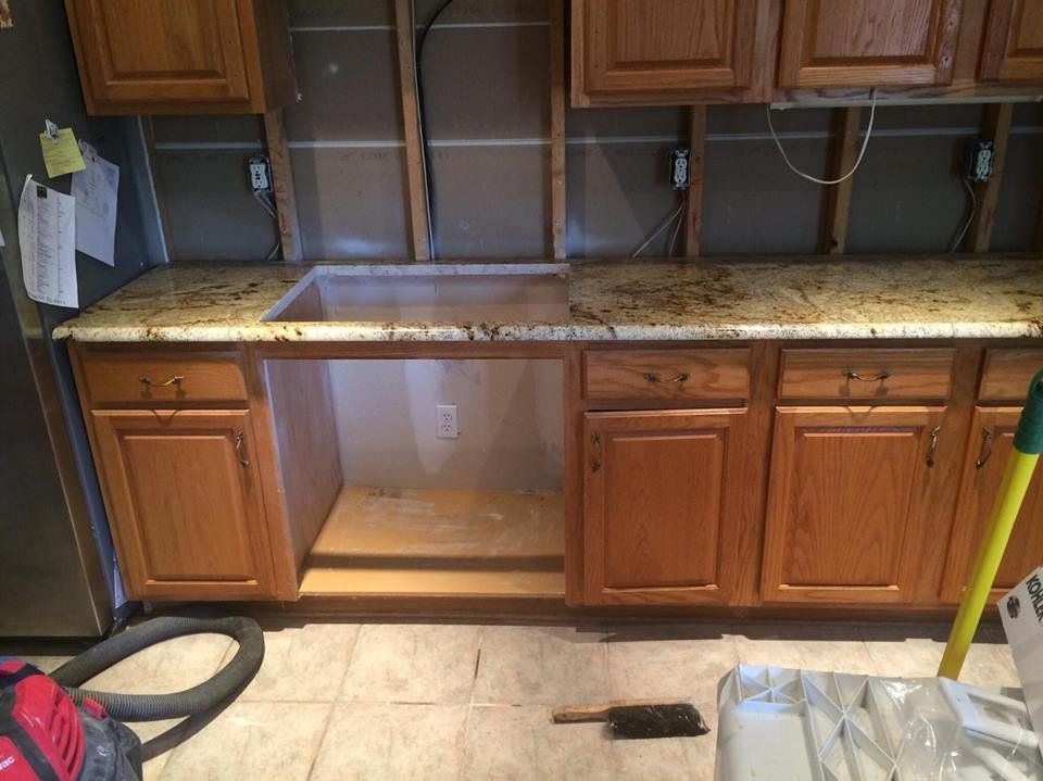 A kitchen with wooden cabinets and granite counter tops is being remodeled.