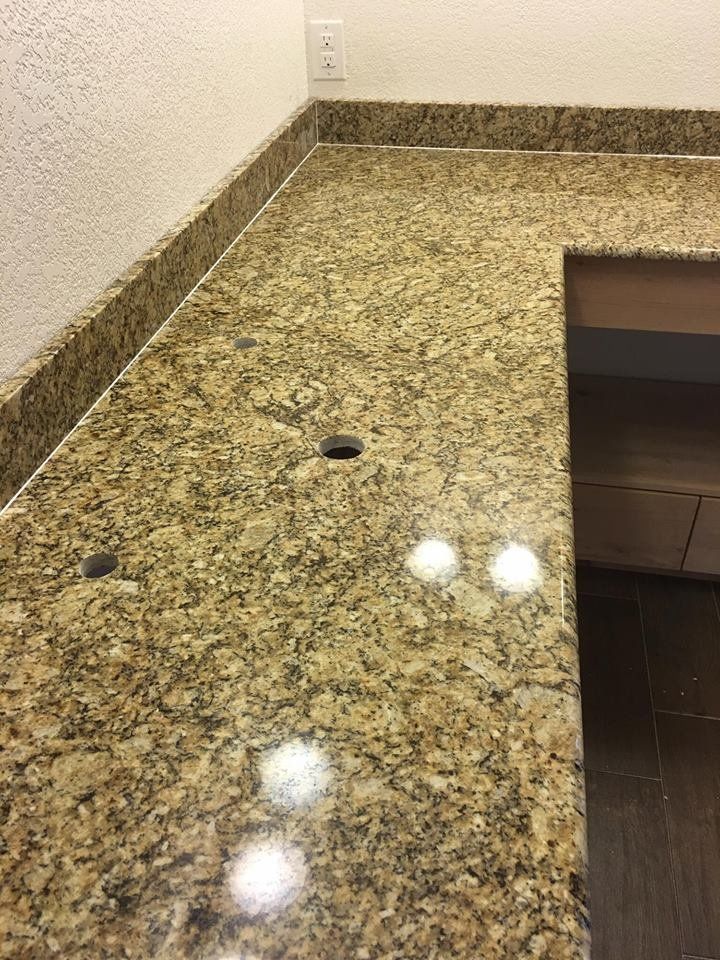 A close up of a granite counter top in a bathroom.
