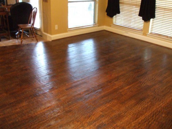 A living room with hardwood floors and two windows
