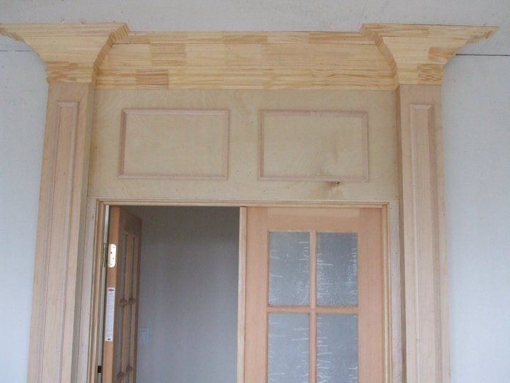 A wooden door in a room with a white wall