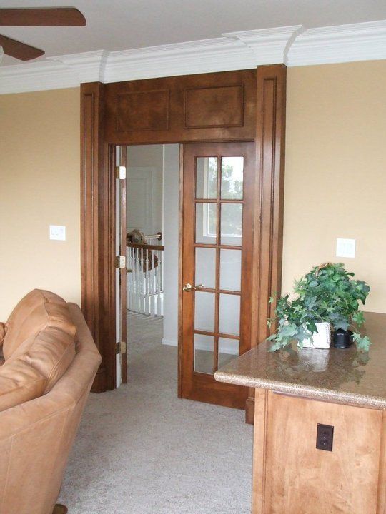 A living room with a brown couch and a french door