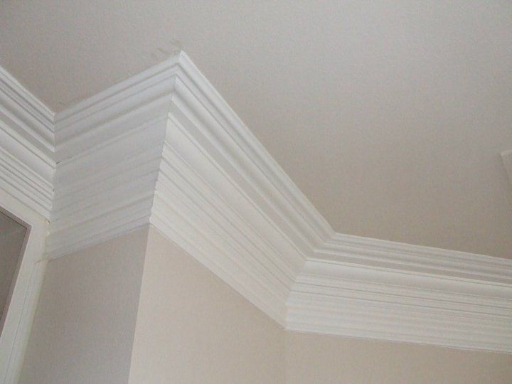 A close up of a white molding on the ceiling of a room.