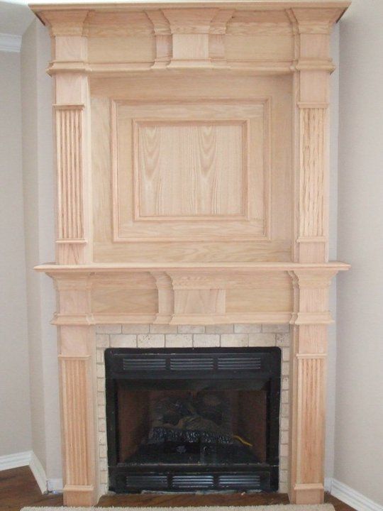 A fireplace with a wooden mantle in a living room