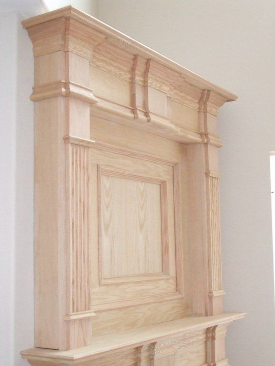 A large wooden fireplace with a shelf underneath it