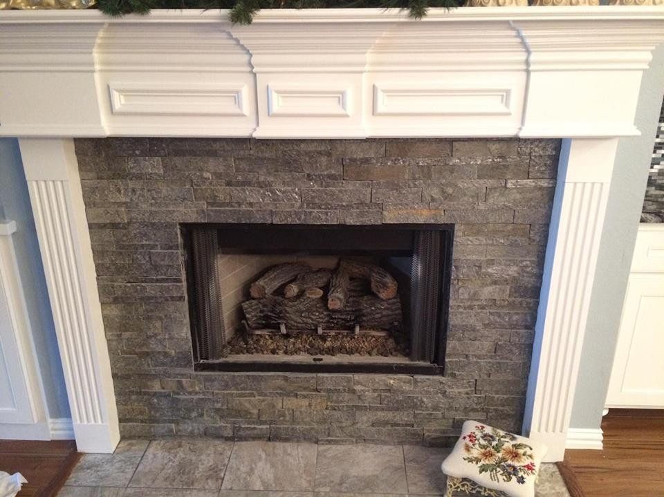 A fireplace in a living room with a white mantle.