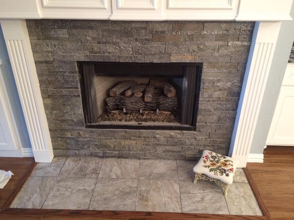 A fireplace with a lot of logs in it in a living room.