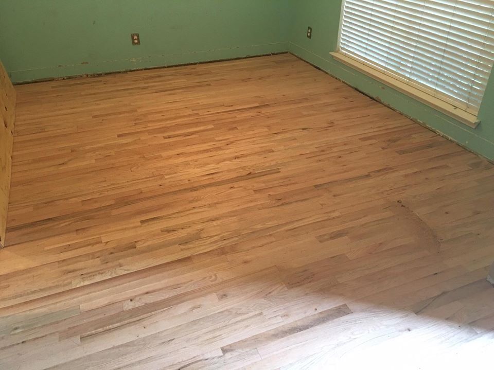A room with a wooden floor and a window.