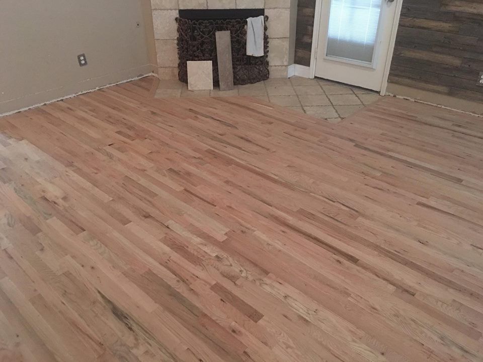 A living room with hardwood floors and a fireplace.