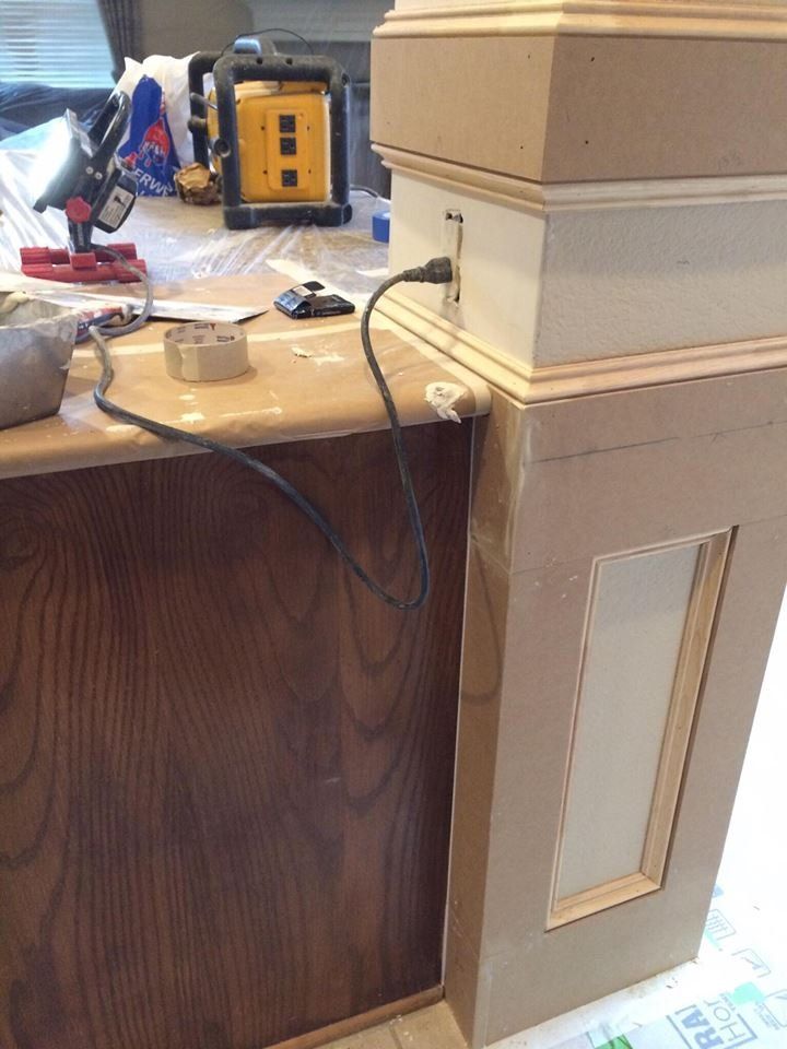 A power cord is plugged into a wooden cabinet