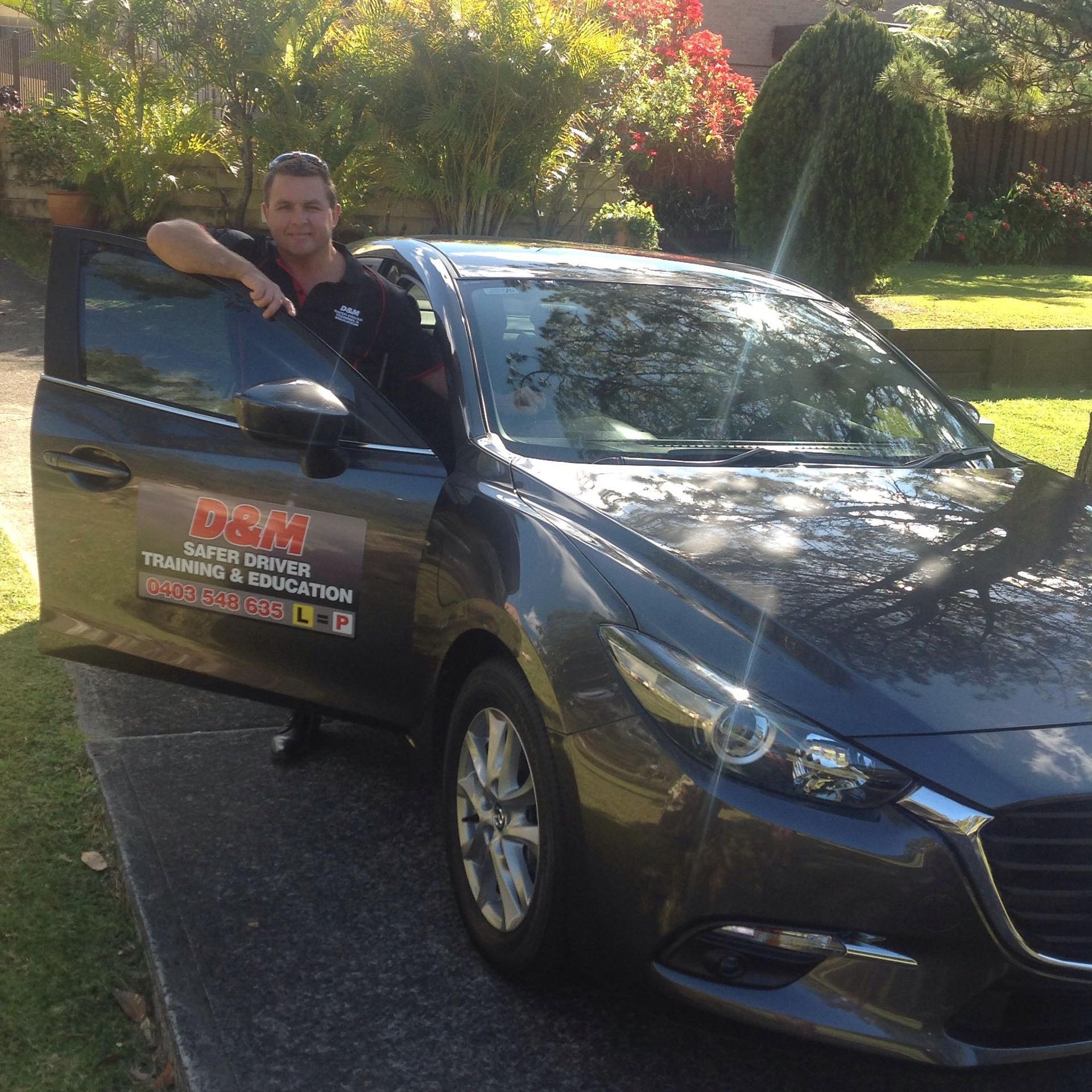 Darran Standing Next To A Car In A Grassy Field — Darran Thompson Driver Training in Wollongong, NSW