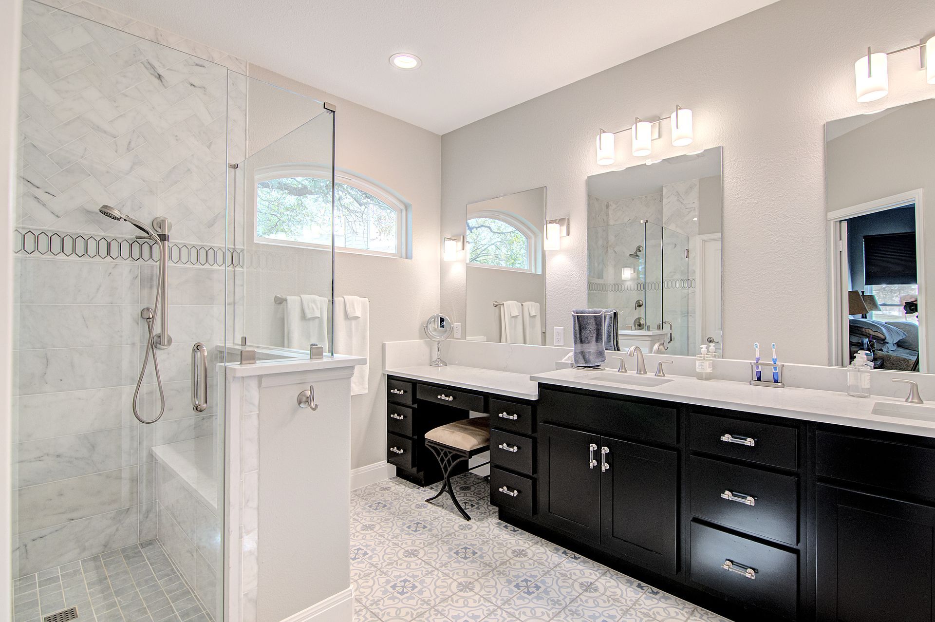 A bathroom with two sinks and a walk in shower.