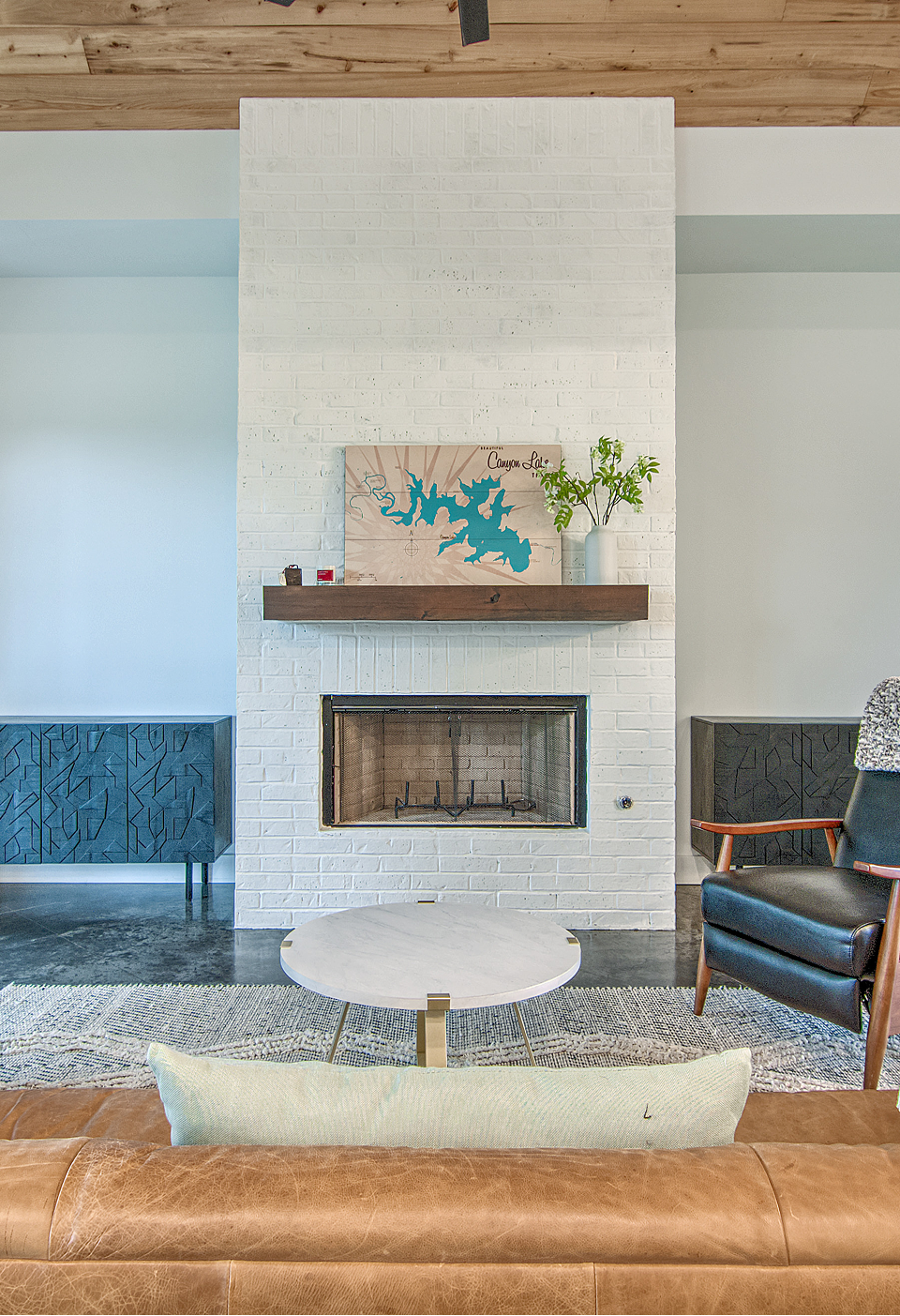 A living room with a fireplace and a ceiling fan.