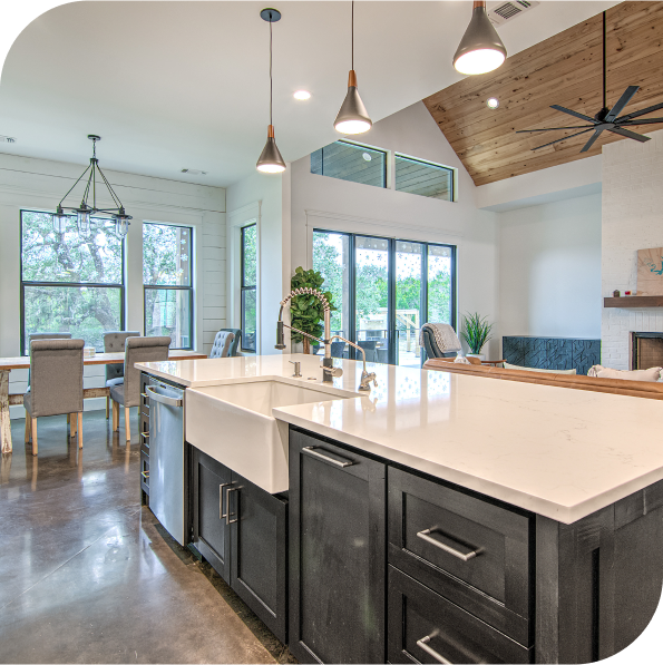 A kitchen with a white sink and black cabinets