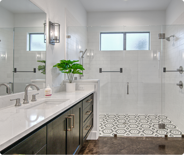 A bathroom with a sink , mirror and walk in shower.