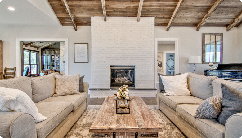 A living room with two couches , a coffee table and a fireplace.