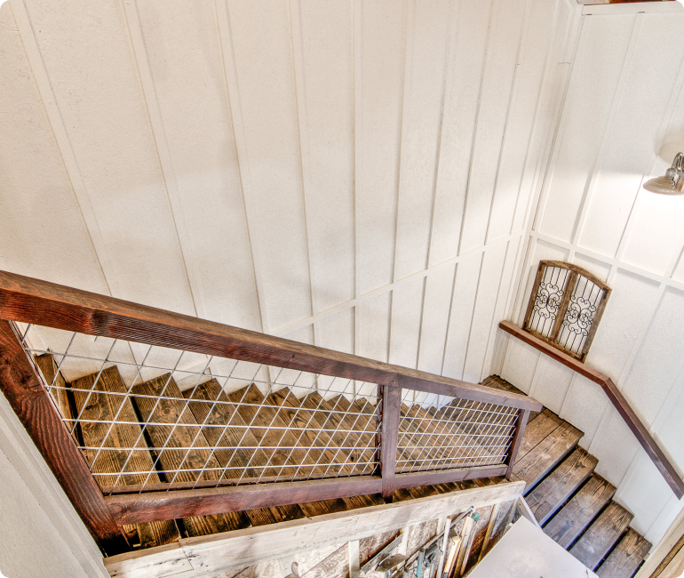 A staircase with a wooden railing and white walls