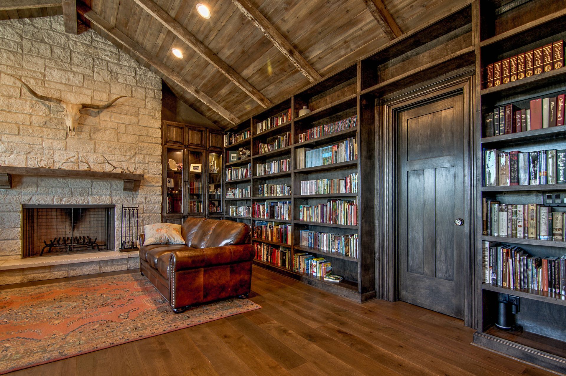 A living room filled with furniture and bookshelves and a fireplace.