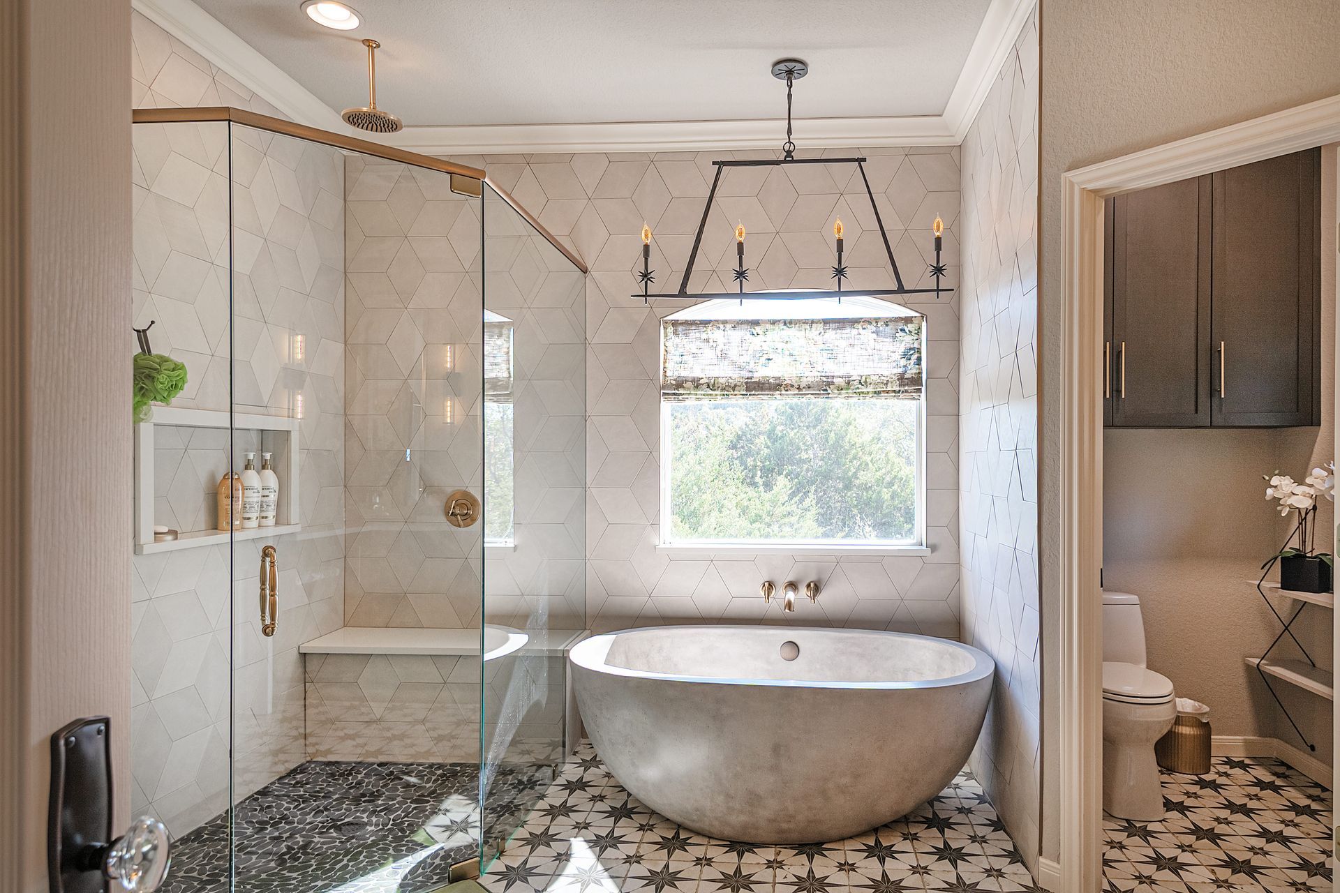 A bathroom with a tub , shower , toilet and window.