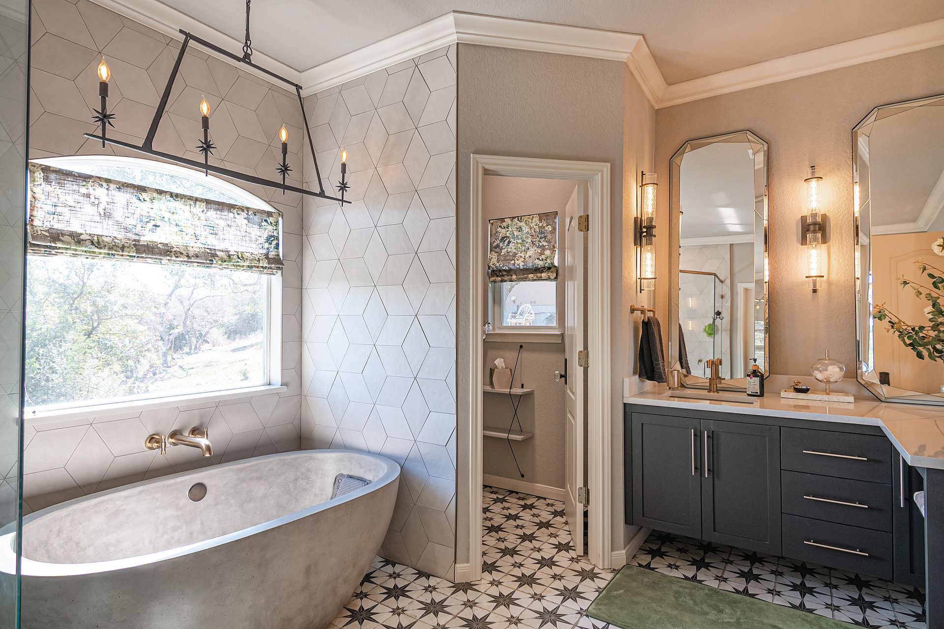 A bathroom with a tub , sink , mirror and window.