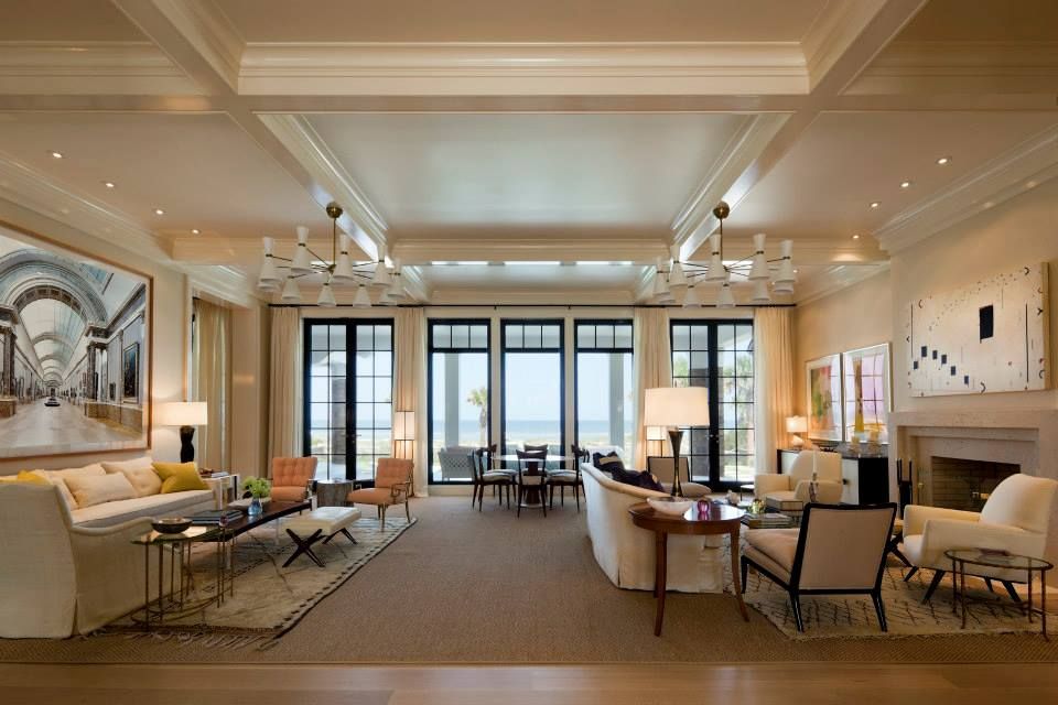 Elegant living room with beige walls, black windows, art, and modern furniture.